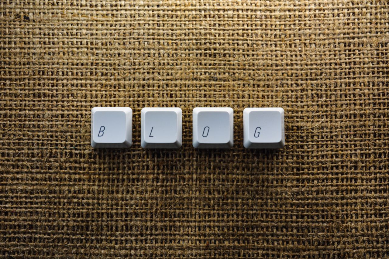 services-01 Close-up of keyboard keys spelling BLOG on a burlap surface, ideal for tech blogs.